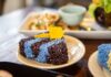 Close-up of vibrant blue and black sticky rice with mango on a plate, showcasing traditional Thai cuisine.
