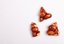 Close-up of almond brittle pieces on a white backdrop, offering tempting texture.