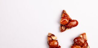 Close-up of almond brittle pieces on a white backdrop, offering tempting texture.