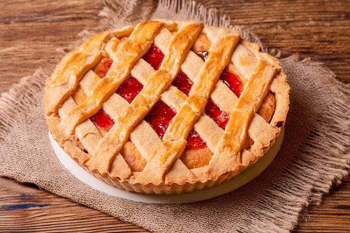 Sobremesa de forno simples caseira: surpreenda a família! A mouthwatering strawberry lattice pie on a rustic wooden table in Lima, Perú.